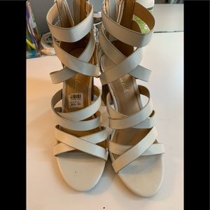 A creamy white strapped up heel